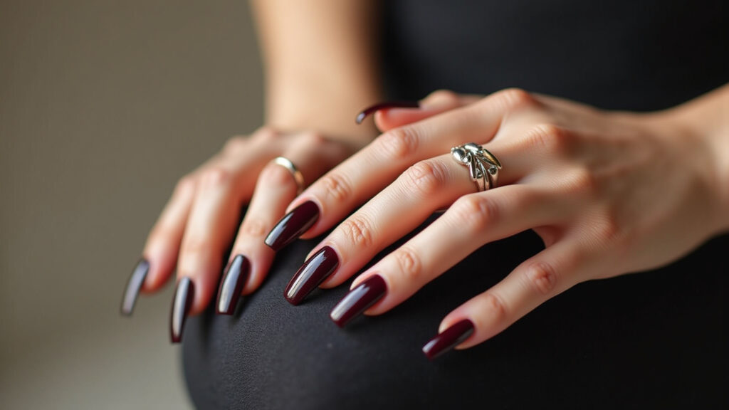 Elegant long round nails, dark wine polish, sophisticated woman's hands, jewelry, professional Unhas redondas alongadas com esmalte vinho.