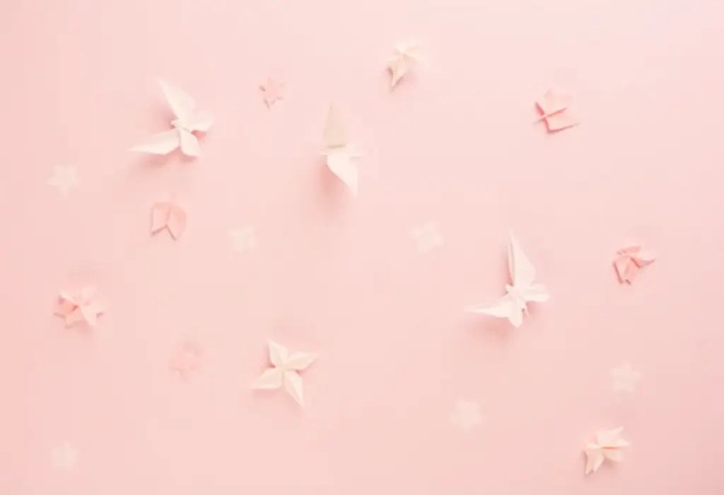 Diversos origamis de animais coloridos em fundo rosa