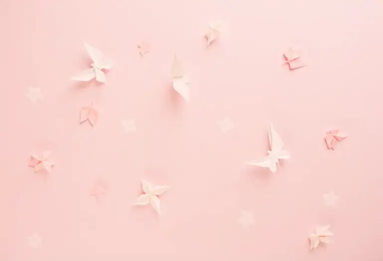 Diversos origamis de animais coloridos em fundo rosa